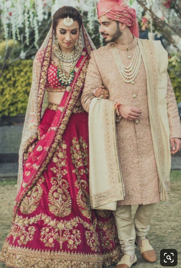 Luxurious Bridel Groom Dress In Red Lahnga Choli And Pinkish Sherwani.Bridal Lahnga Choli Embalished With Pure Dabka,Zari,Nagh,And, Threads Work.Groom Sherwani Based On Pure Jamawar Fabric In Light Pinkish Color.Sharwani Work On Gala And Sleeves With Dabka And Nagh Work.It Is Complete Packeg Of Bride And Groom Outfit.