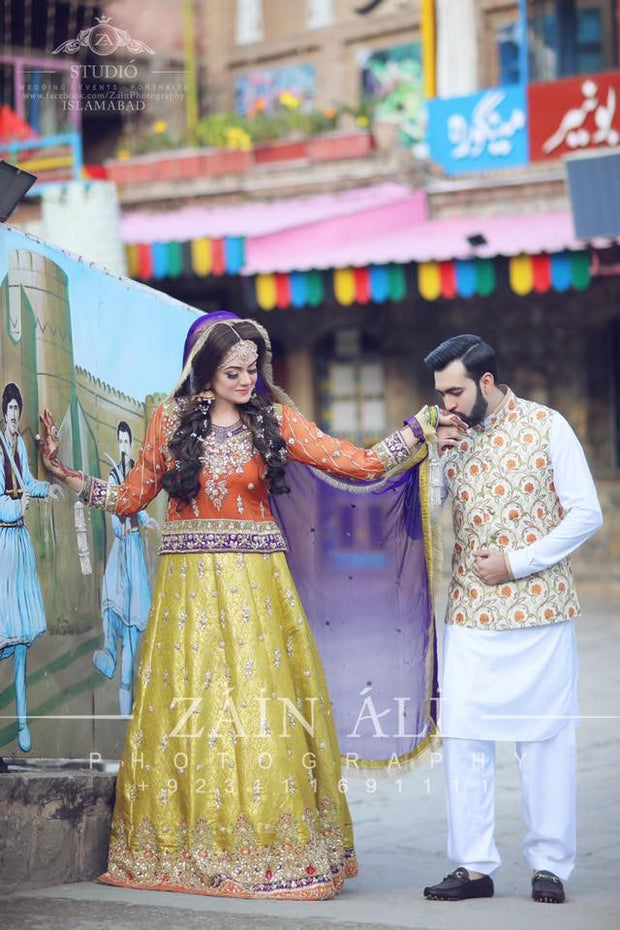 Stylish Mehndi Attire In Orange Green And Purple Color.Work Embellished With Dabka Zari And Gota Work.