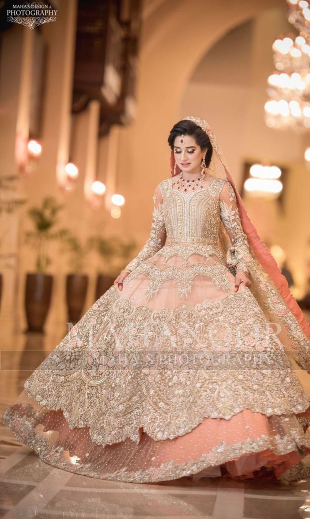 Walima Bridal Dress In Beutifull Peachy Pink Color.Work Embalishment With Pure Dull Gold And Silver Dabka,Nagh,Zari Pearls,Stones,Crystal And Dhaga Flower Work.Beutifull Dress Can Custumized In Any Color.Fabric Can B Change As Per Customer Drsiring Fabric.